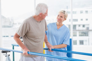 Senior man walking with therapist help